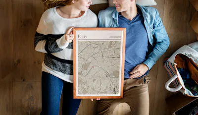 Auf dem Rücken liegendes Liebespaar mit einem gerahmten Stadtplan von Paris im Japandi-Stil